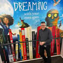 Proud author, Jonas Lane, standing next to the spine of his book, Slipp In Time.