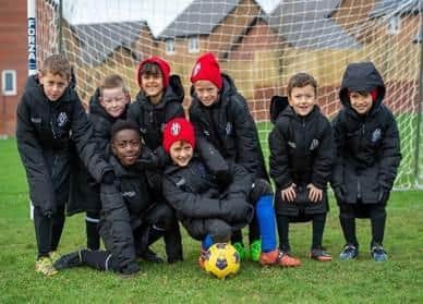 The young footballers are thrilled with their new coats