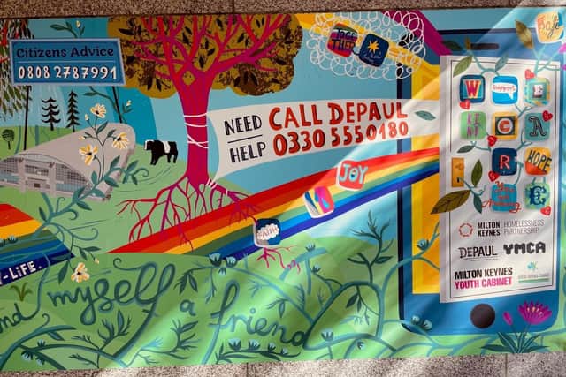 The mural contains a helpline number
