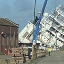 A ship is currently leaning towards the docks at a worrying angle in Leith, Edinburgh. (Photo credit: @Tomafc83 on Twitter)