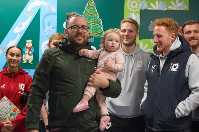 The MK Dons players pose with parents and poorly youngsters in their annual hospital visit