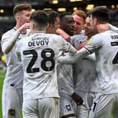 MK Dons celebrate Mo Eisa's brilliant free-kick which was the difference between the sides against Cambridge United