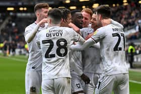 MK Dons celebrate Mo Eisa's brilliant free-kick which was the difference between the sides against Cambridge United