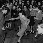 Schoolboy Ken Perry and his dance partner, schoolgirl Susan Green, winners of the Bletchley Road County Secondary School dance competition, demonstrate their moves to their schoolmates during the lunch hour dance session in the school hall in 1957.