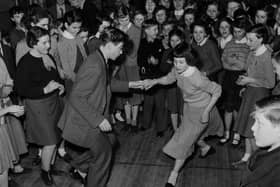 Schoolboy Ken Perry and his dance partner, schoolgirl Susan Green, winners of the Bletchley Road County Secondary School dance competition, demonstrate their moves to their schoolmates during the lunch hour dance session in the school hall in 1957.