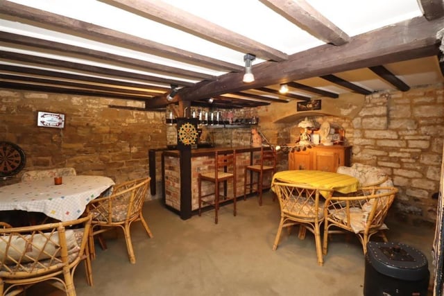 A cellar is used as an entertainment room complete with bar; it has exposed stone walls and beamed ceiling with lobby area useful for storage.