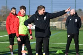 Dons boss Mark Jackson gives instructions during a much-needed spell on the training pitch for MK Dons