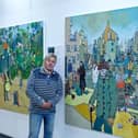 Jack Watto with his painting on damage to infrastructure, one of the eight paintings on display in the Art for Planet Earth exhibition.