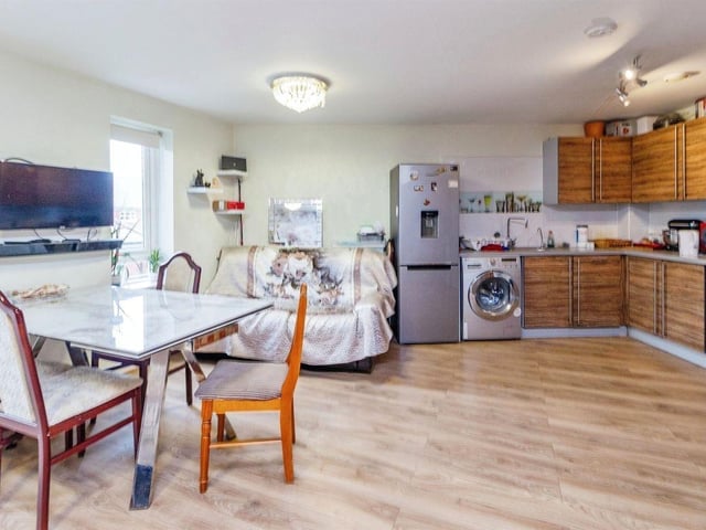 The kitchen area includes a sink with splash back tiles, cooker, space for washing machine and fridge freezer.