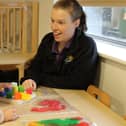 A Kiddi Caru nursery and preschool staff member playing with toddler.