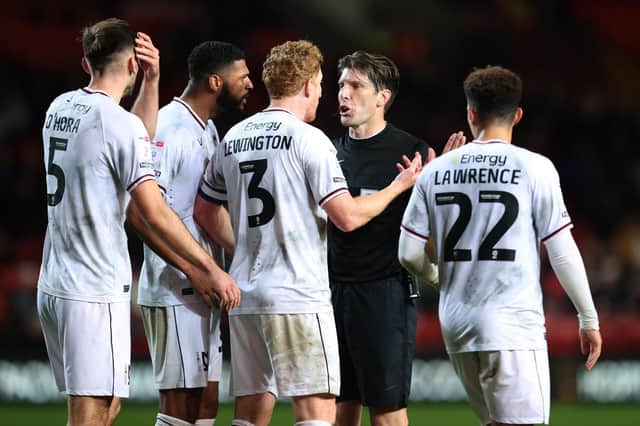LONDON, ENGLAND - OCTOBER 25: MK Dons players surround the referee during the Sky Bet League One between Charlton Athletic and Milton Keynes Dons at The Valley on October 25, 2022 in London, England. (Photo by Alex Pantling/Getty Images)