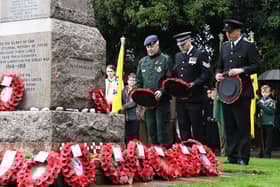 People gather round the war memorial in Bletchley to pay their respects