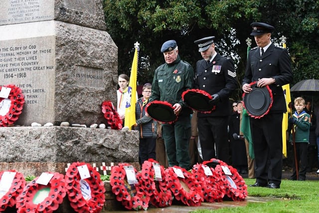 People gather round the war memorial in Bletchley to pay their respects