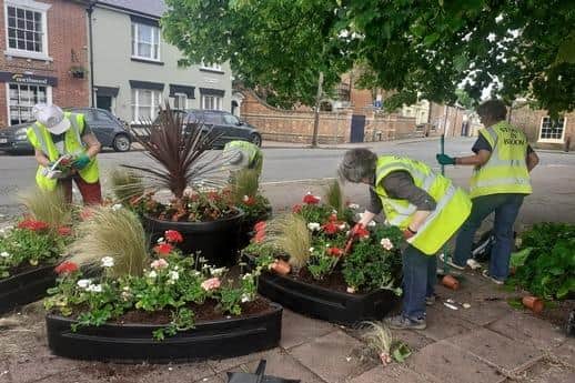 Volunteers add the final touches to the flower displays