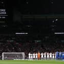 The players of England and Greece pause for a minutes' silence ahead of kick-off in honour of the passing of former MK Dons footballer George Baldock