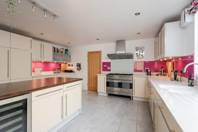 The kitchen offers a breakfast island with family-sized fridge, range cooker, and stylish Corian working surfaces, plus wine cooler with a ready supply of beverages to complement meals in the dining room, or in summertime on the terrace decking