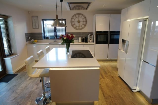The spacious kitchen/dining area has been refitted with a German Hacker kitchen featuring quartz worktops inset sink with mixer tap over, built in appliances space for American fridge freezer, built in dishwasher, central breakfast bar island with cupboards under and Quartz worktop, built in Neff induction hob with Neff extractor over, open to utility, tiled to splash back area, wood effect porcelain tiled floor with underfloor heating.