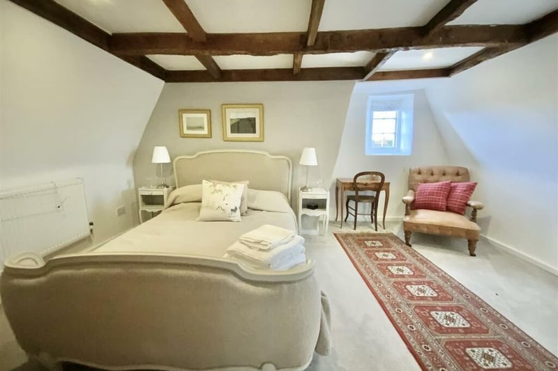 One of the six beautiful bedrooms with feature exposed timbers