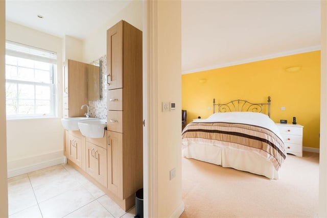 The master suite includes sash windows, two fitted double wardrobes, a walk-in dressing room and an en-suite shower room with two wash basins.