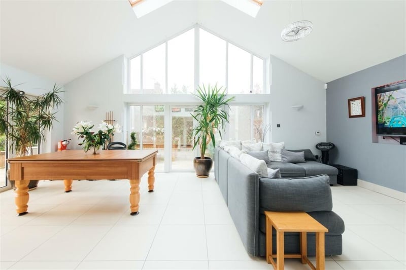 The large open plan dining room and family room features a stunning high vaulted ceiling with feature floor to apex glazing and skylight windows, French doors to the side and bi-fold doors to the rear garden. There is a feature recess for a wall mounted TV.