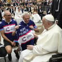 Tim Dryburgh and Scott Dryburgh, left and centre, from Milton Keynes, hand over a personalised Cancer Research UK cycling vest to Pope Francis as a thank you for blessing their journey from Rome to London.