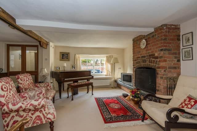 The sitting room has a brick-built open fireplace, beams to the ceiling, and double doors to the kitchen/dining area, family room and a further door leading to the study.