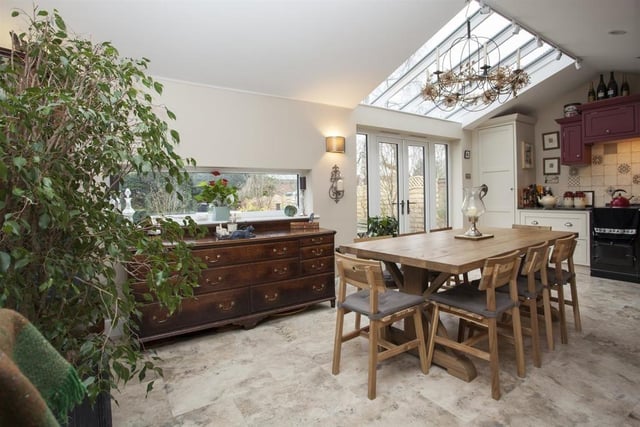 The large kitchen has a dining area and a family area with two pairs of French doors leading to the garden via the patio.