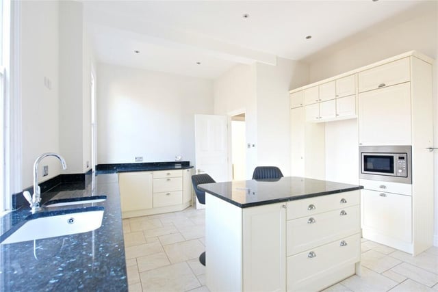 The kitchen has a range of base and eye level Shaker style units, including a central island – all with granite work surfaces and splashbacks and with a Belfast sink. Integrated appliances include a microwave and a dishwasher, space for an American style fridge/freezer and a gas fired range cooker.