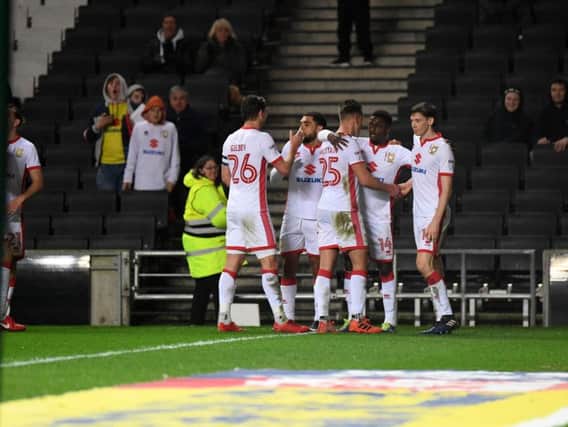 Dons players celebrate Kieran Agard's penalty equaliser. Picture by Jane Russell