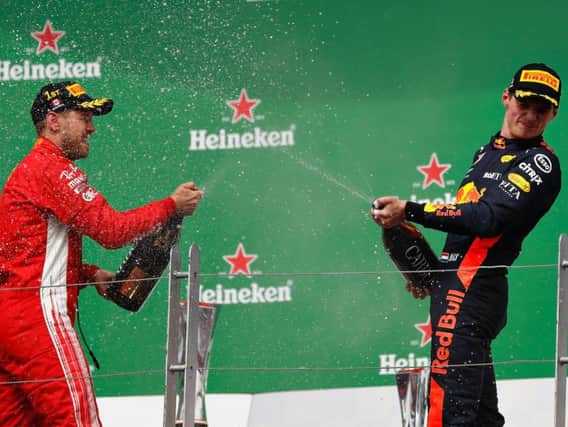 Max Verstappen (r) celebrates on the podium with Sebastian Vettel (l)