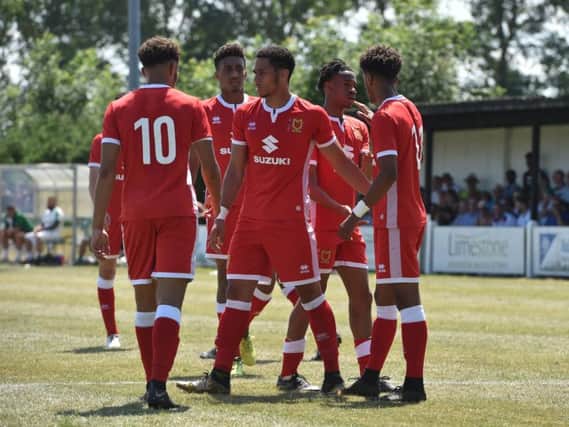 MK Dons celebrate scoring against Newport Pagnell Town