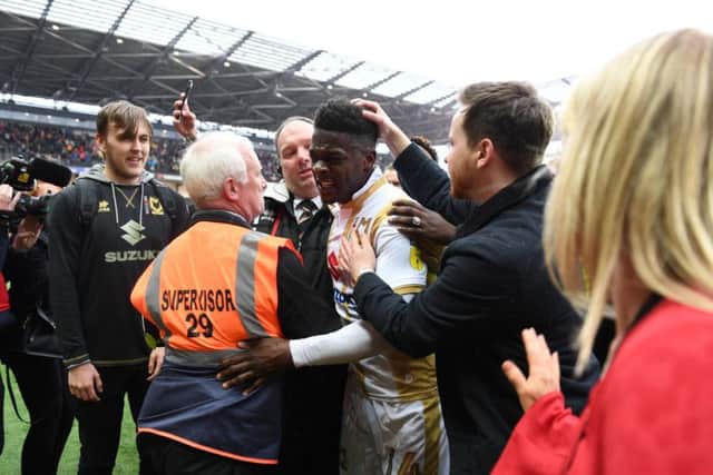 Kieran Agard is mobbed as he leaves the pitch