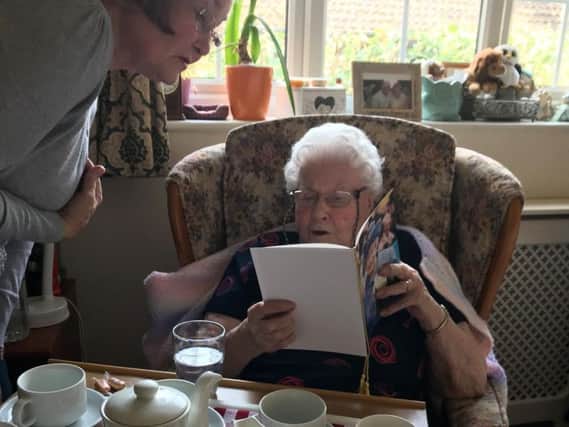 Marjorie opening her letter from the Queen