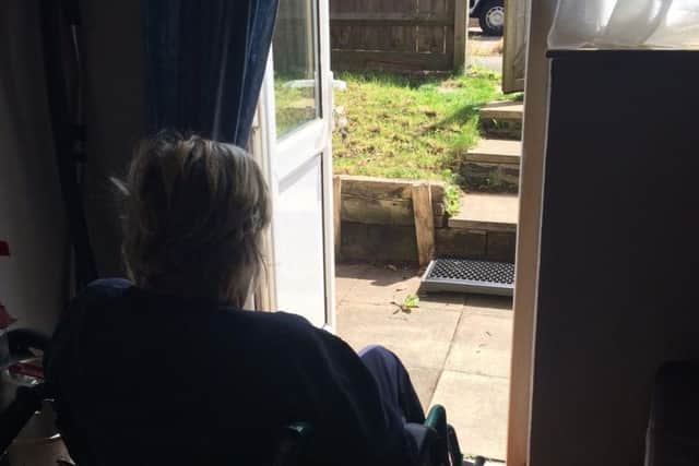 Annette looking out from her flat at the steps which have her trapped in her own home