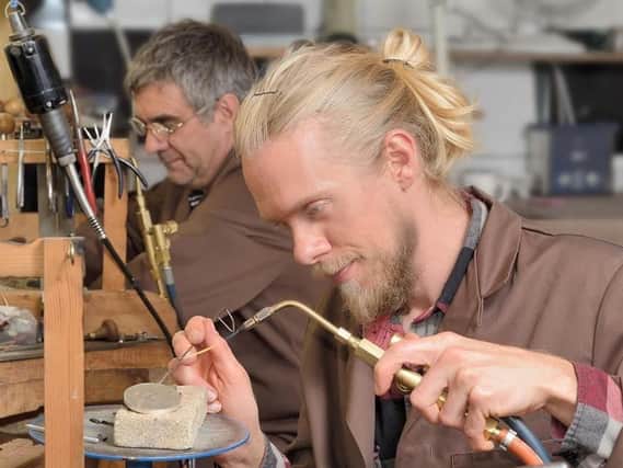 Paul Chapman hand crafts jewellery with his blowtorch as father Glen works away in the background