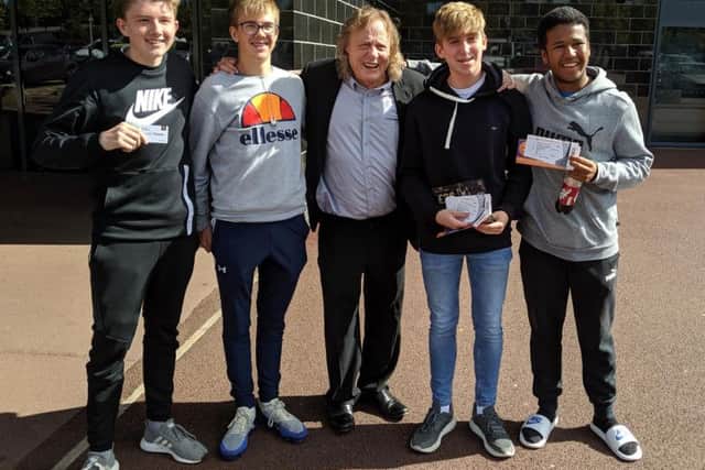 Fans pose with Dons chairman Pete Winkelman after buying their Liverpool tickets