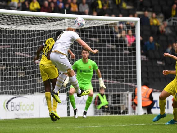 Dean Lewington goes got goal with a header during MK Dons' 3-0 defeat to Burton Albion (Pictures: Jane Russell)