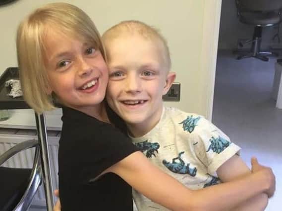 Little Libby Tucker-Spiers, who dreamt of being Rapunzel, cut her long hair for cancer sufferer Aiden Selleck, right