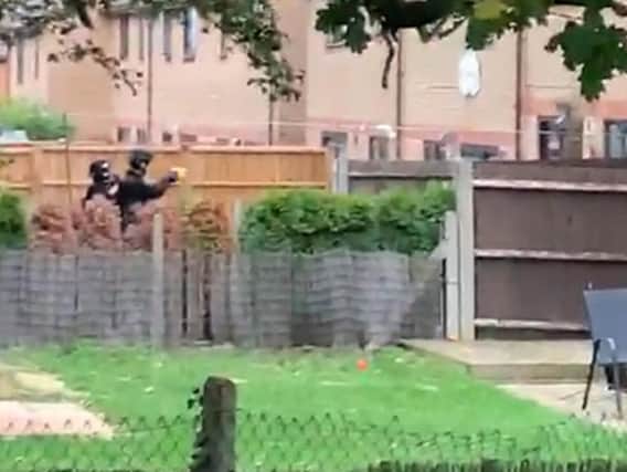 Armed police filmed in garden of home at the centre of armed siege