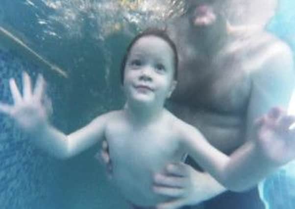 Three year old Freya waves to the camera underwater during the Waterbabies class at the Bodyflight pool in Bedfordshire. The classes for babies up to the age of 4 run all over the country.