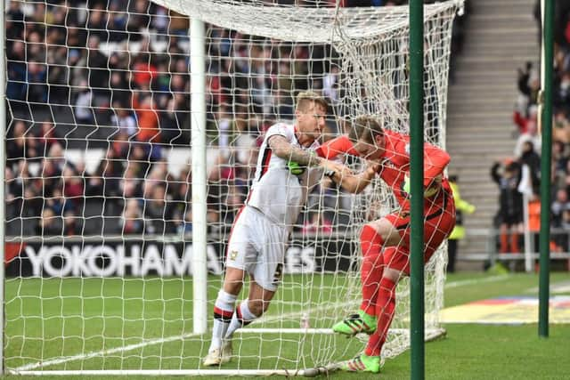 Kyle McFadzean clashes with Brighton keeper David Stockdale. PNL-160320-170330002