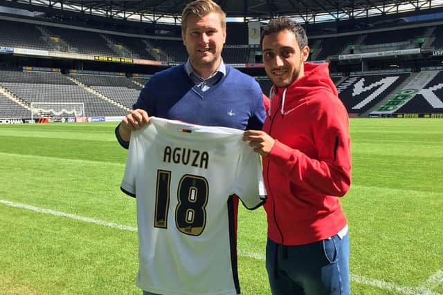 Sergio Aguza gets his new shirt from Karl Robinson