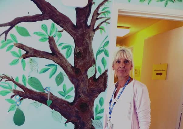 Ann Saunders and the memory tree she painted.