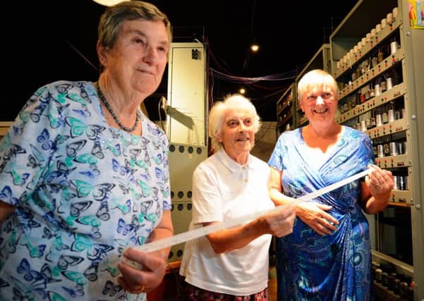 Original EDSAC users, Joyce Wheeler, Margaret Marrs and Liz Howe showing a recreated paper tape that ran a very early computer find-a-prime-number program.
 Photo by John Robertson for TNMOC.