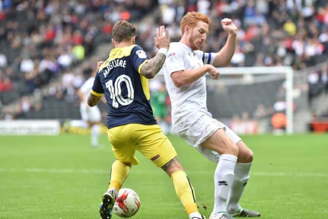 Oxford's Chris Maguire goes toe-to-toe with Dean Lewington.