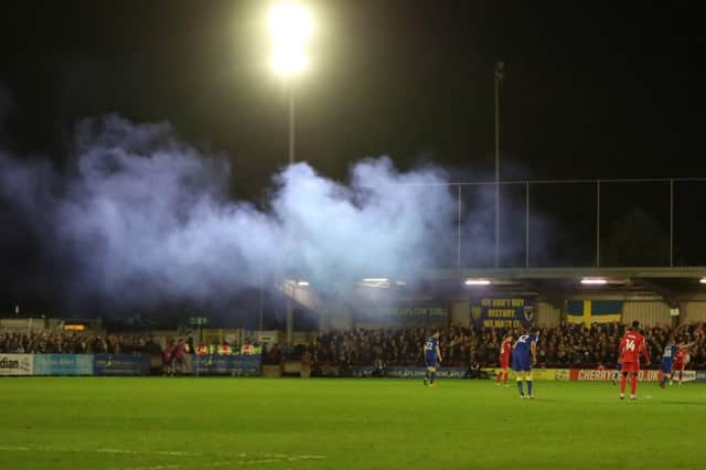 A smoke flare goes off during the EFL Sky Bet League 1 match between AFC Wimbledon and Milton Keynes Dons at the Cherry Red Records Stadium, Kingston, England on 14 March 2017. PSI-3497-0084