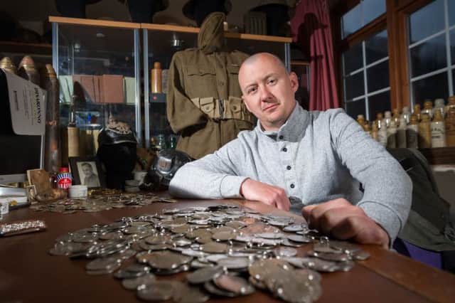 Dan Mackay, 37, discovered the military tags under the earth beside the site of a World War Two anti-aircraft battery just outside London.  Photo: SWNS