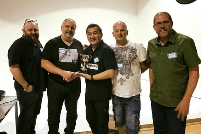 New City Photographic Society winning team, from left, Jamie White, Colin Mill,  Mark Jones, and Dave Cromack, receive their prize from Will Cheung, centre. 3fNX8fNpfYGc0tDq9opD