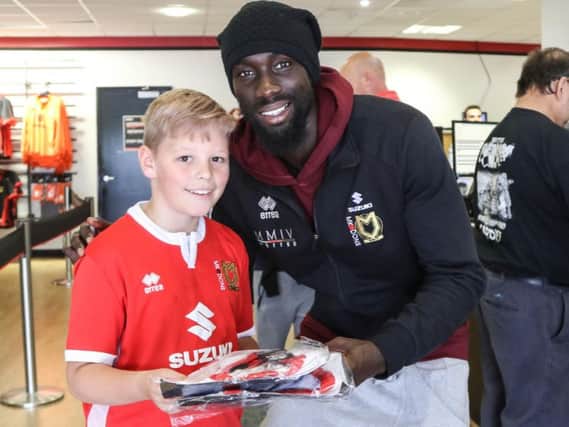 Ousseynou Cisse hands over a shirt to a young fan