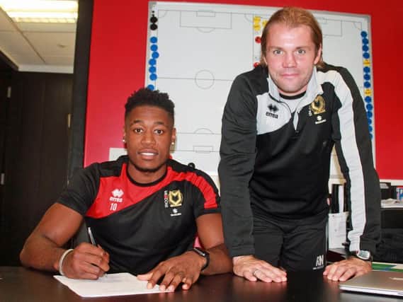 Chuks Aneke signs his new contract with boss Robbie Neilson. Pic: MK Dons